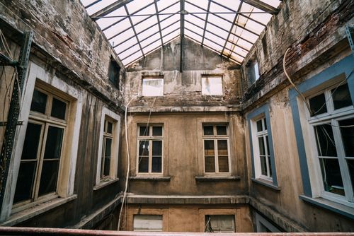 Free A decaying building interior with a glass rooftop, showcasing urban decay and emptiness. Stock Photo