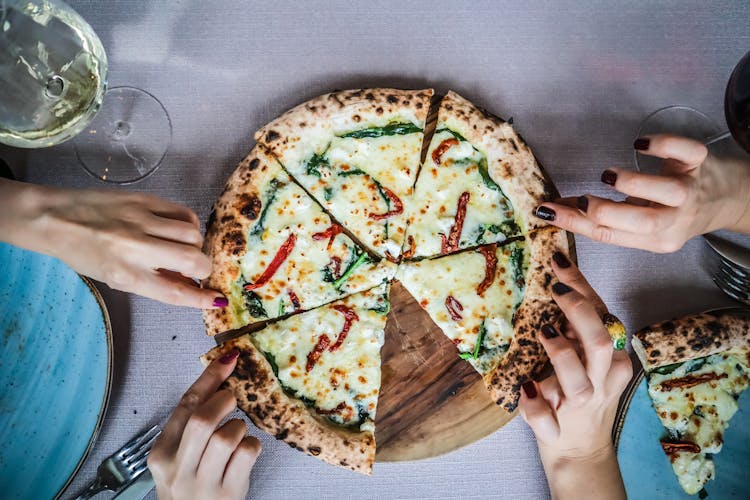 Hands Holding Pizza Slices 