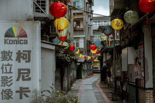 Vibrant Chinese lanterns decorate a traditional alleyway, creating a festive atmosphere.