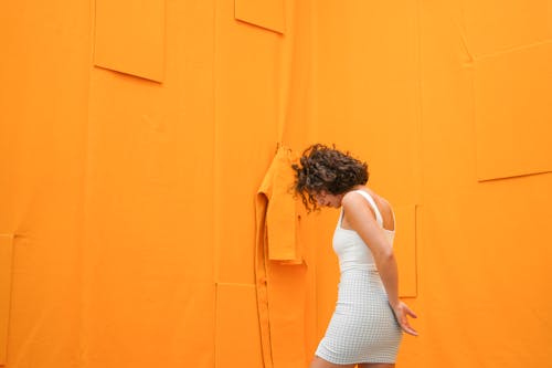 Woman Standing Beside Orange Wall