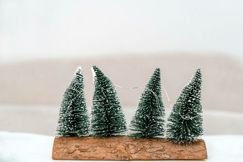 Free Handmade miniature Christmas trees on wood base, perfect for holiday decoration. Stock Photo
