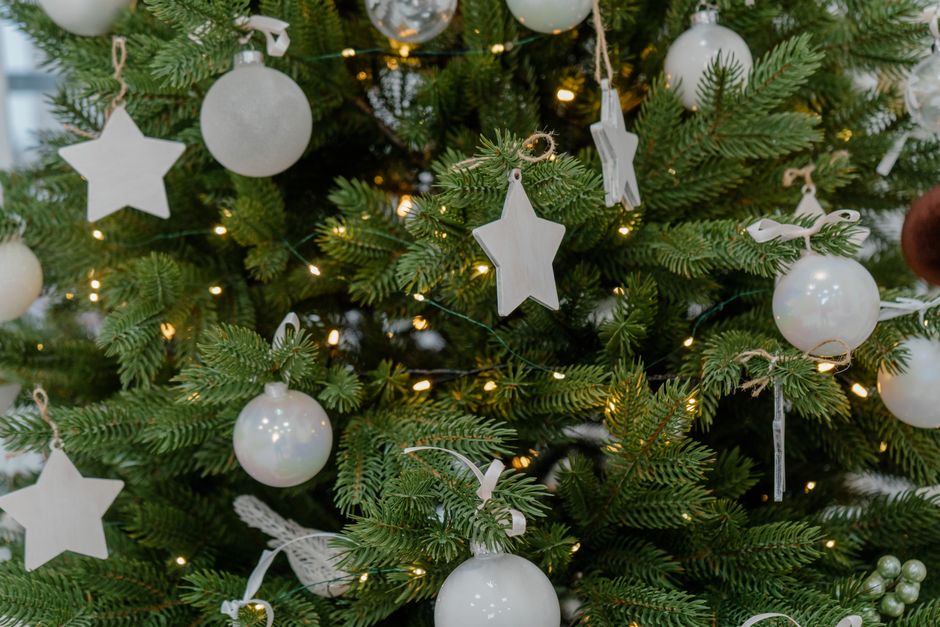 Close-up of an elegant Christmas tree adorned with white ornaments and stars.
