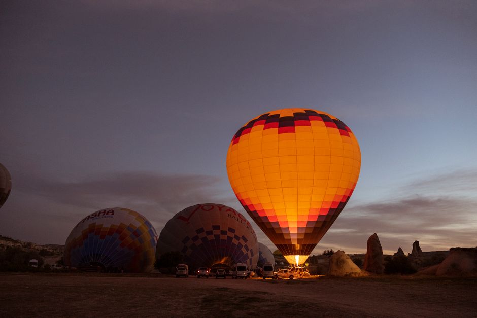 A glowing hot air balloon prepares to lift off against a picturesque dusky sky, capturing the magic of a rural adventure.