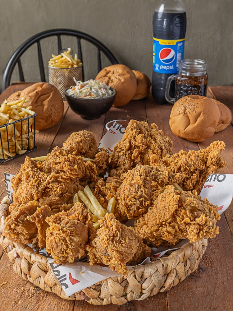 A Bunch Of Fried Chicken And Fries On A Woven Basket 