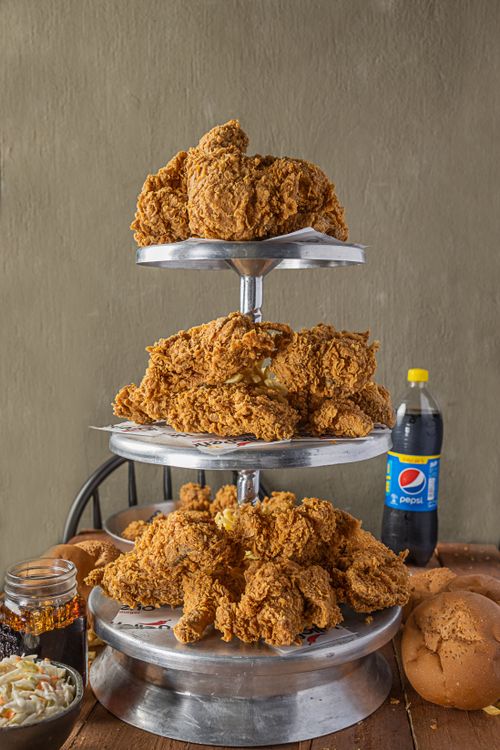 Free A mouthwatering stack of crispy fried chicken served with sides and a soda, perfect for food lovers. Stock Photo