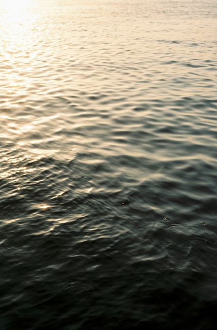 A serene view of the sun reflecting on the tranquil waters of Alicante during sunset.