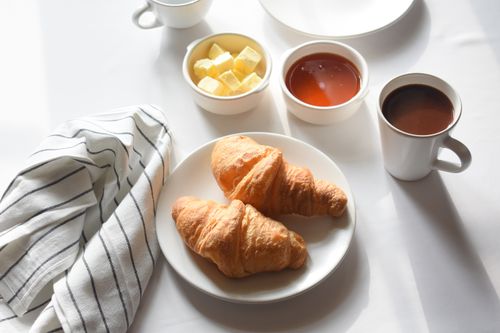 Free Savor a classic breakfast with buttery croissants and steaming coffee. Perfect start to your day. Stock Photo