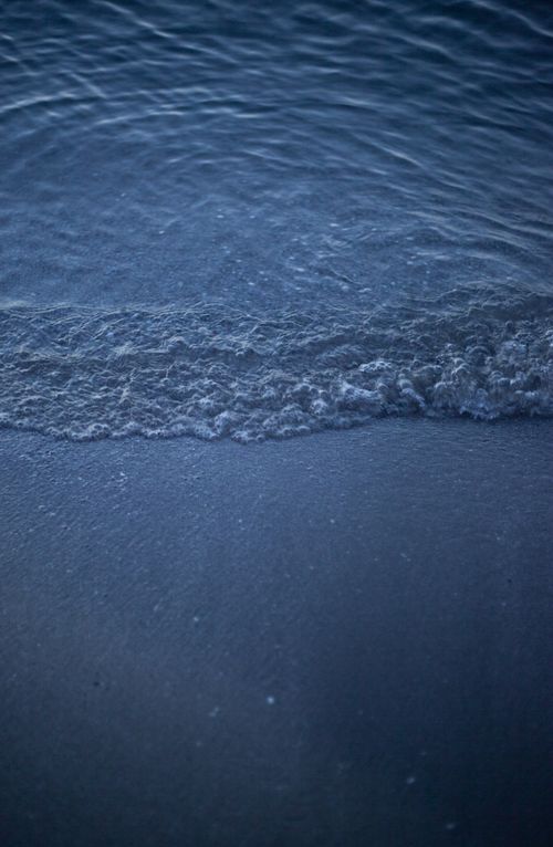 Free Calm waves gently lapping the sandy beach at twilight, creating a tranquil seaside scene. Stock Photo