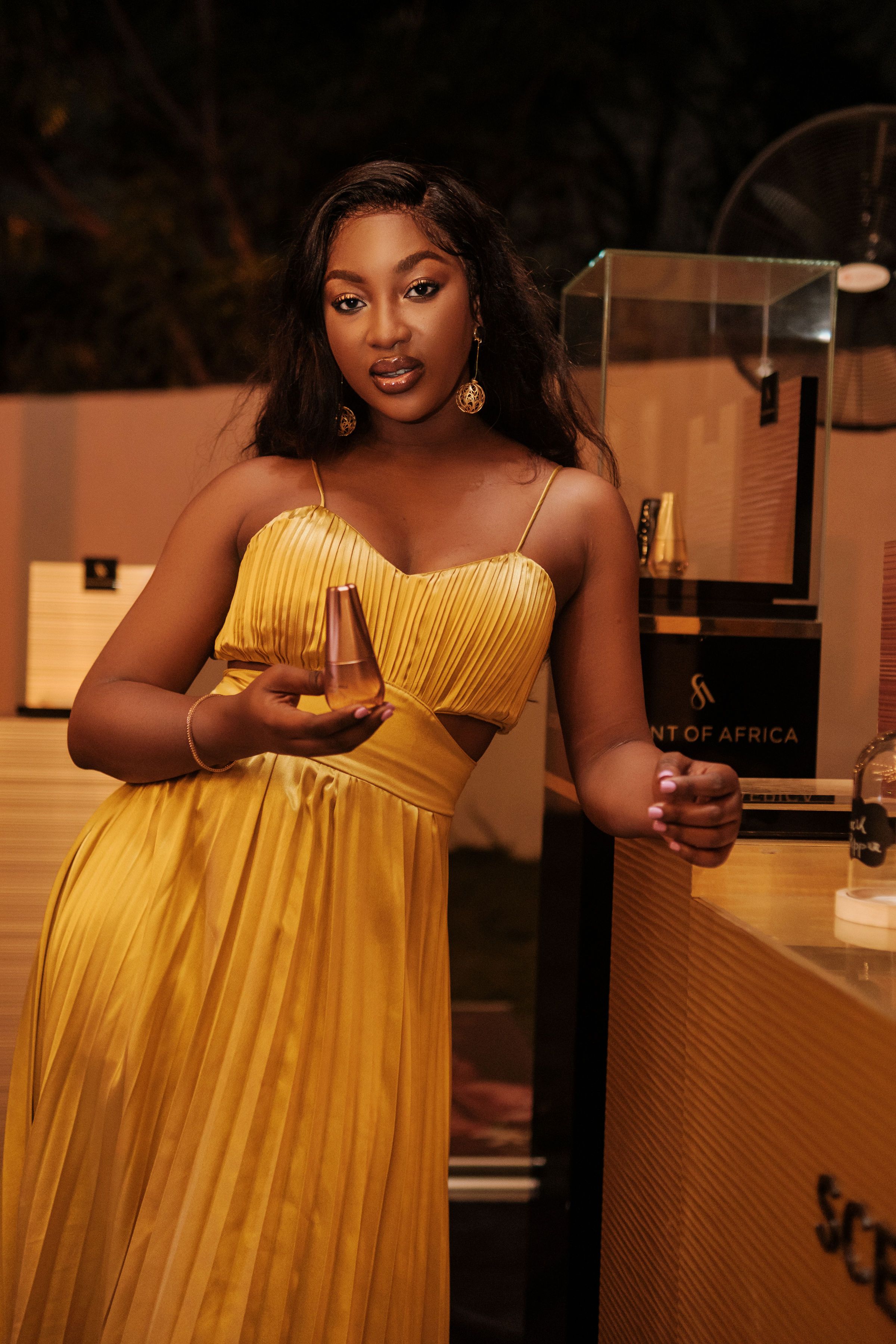 Mulher estilosa em um vestido amarelo posando em ambiente interno, capturando elegância e moda.