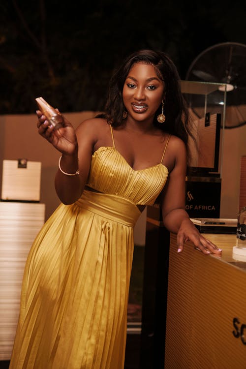 Beautiful Woman Standing and Holding a Perfume Bottle 