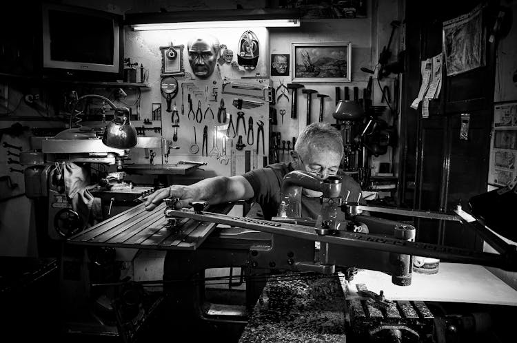 A Man Using An Equipment In A Workshop