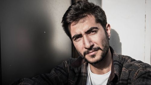 Free Close-up portrait of a confident man with a beard outdoors, embracing natural light. Stock Photo