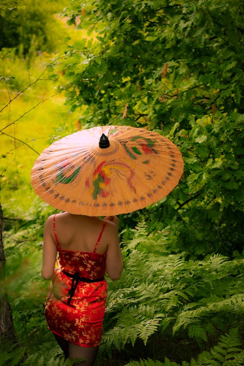 Woman under Umbrella among Lush Foliage