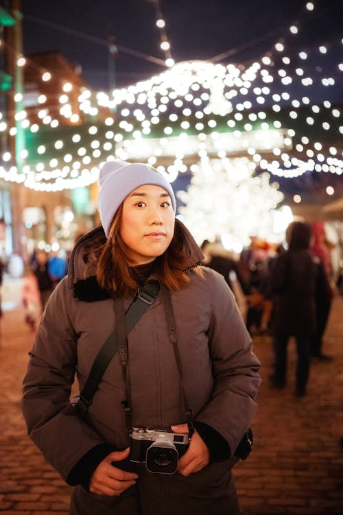 Woman in Winter Clothing Holding a Camera