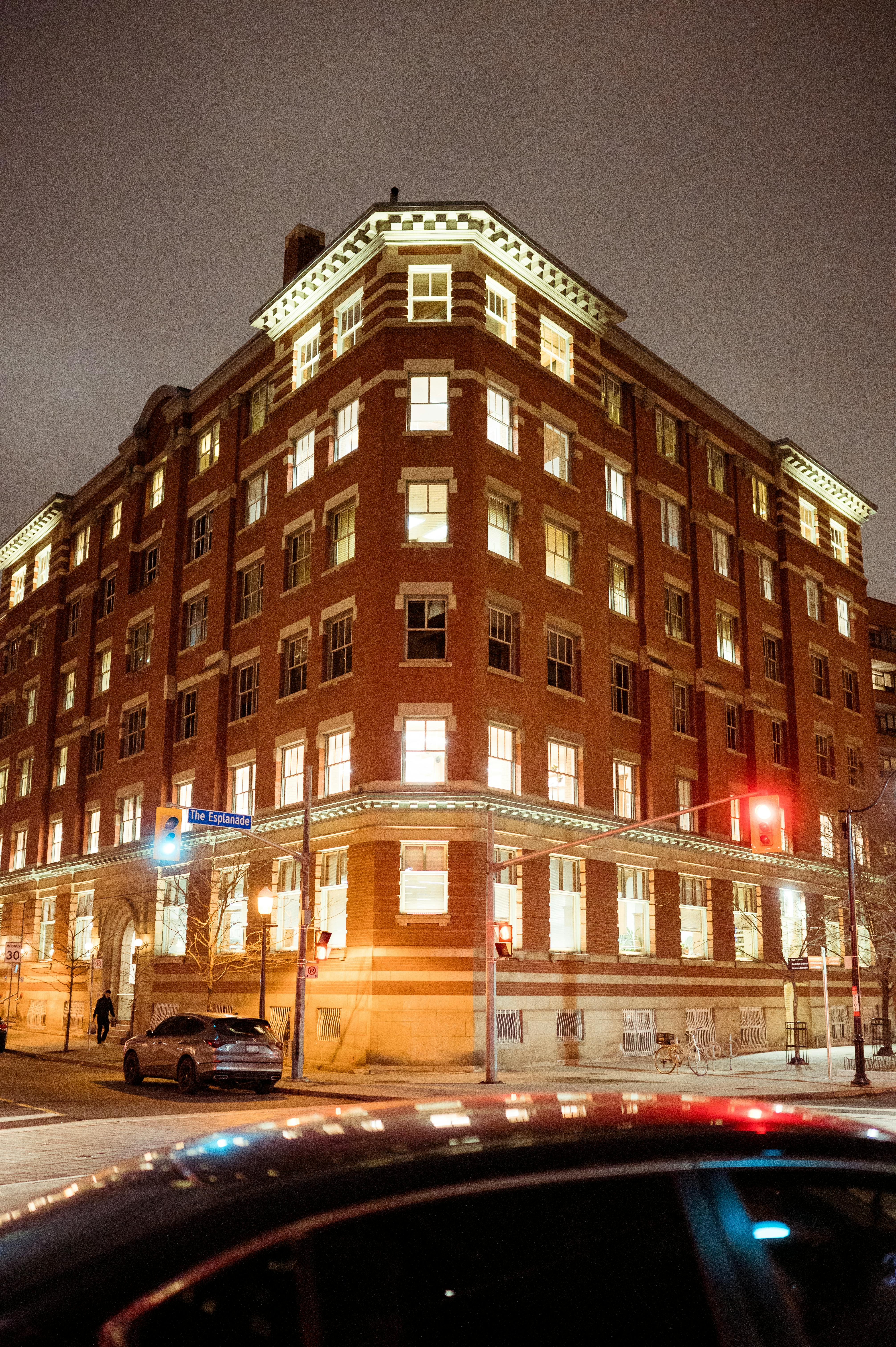 Free A brightly lit historic building in a city at night with street view. Stock Photo