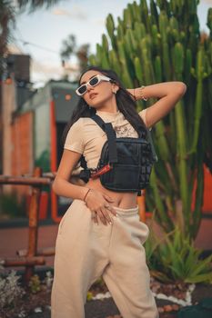 Fashionable young woman posing confidently in casual outdoor setting.