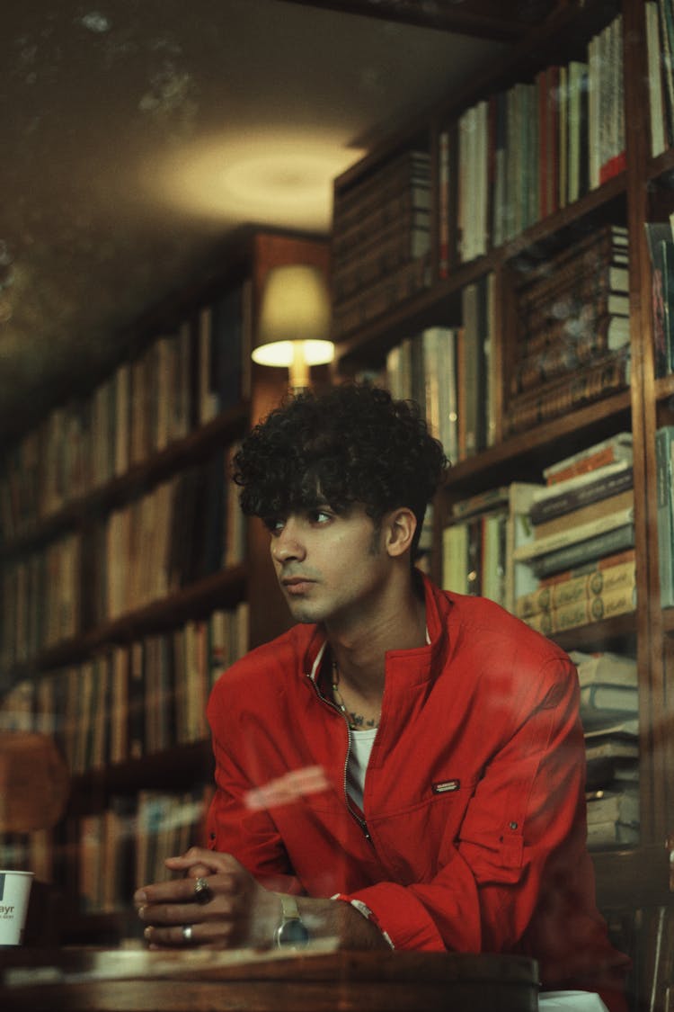 A Man Sitting In A Library