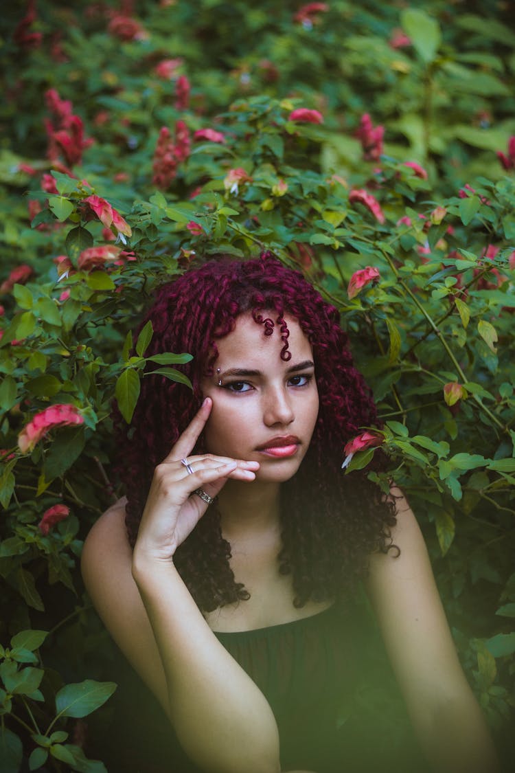 Portrait Of Woman Sitting Under Flowering Plant