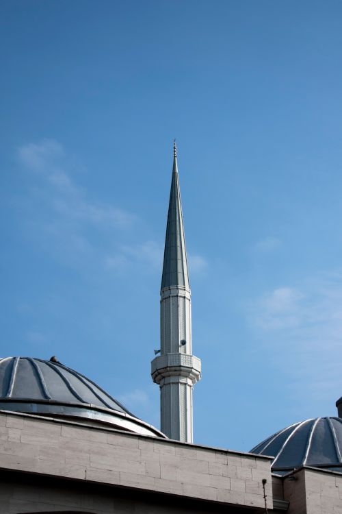 Free A striking minaret of a mosque stands tall against a clear blue sky. Stock Photo