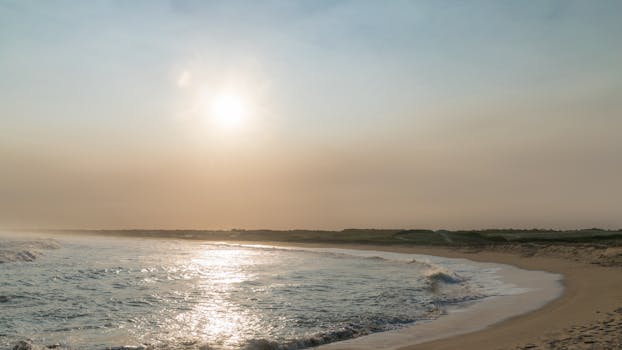 Quiet beach scene at Punta del Diablo, Uruguay with soft waves and a warm sunrise.