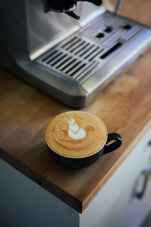 Free Coffee with Foam next to Coffee Machine Stock Photo