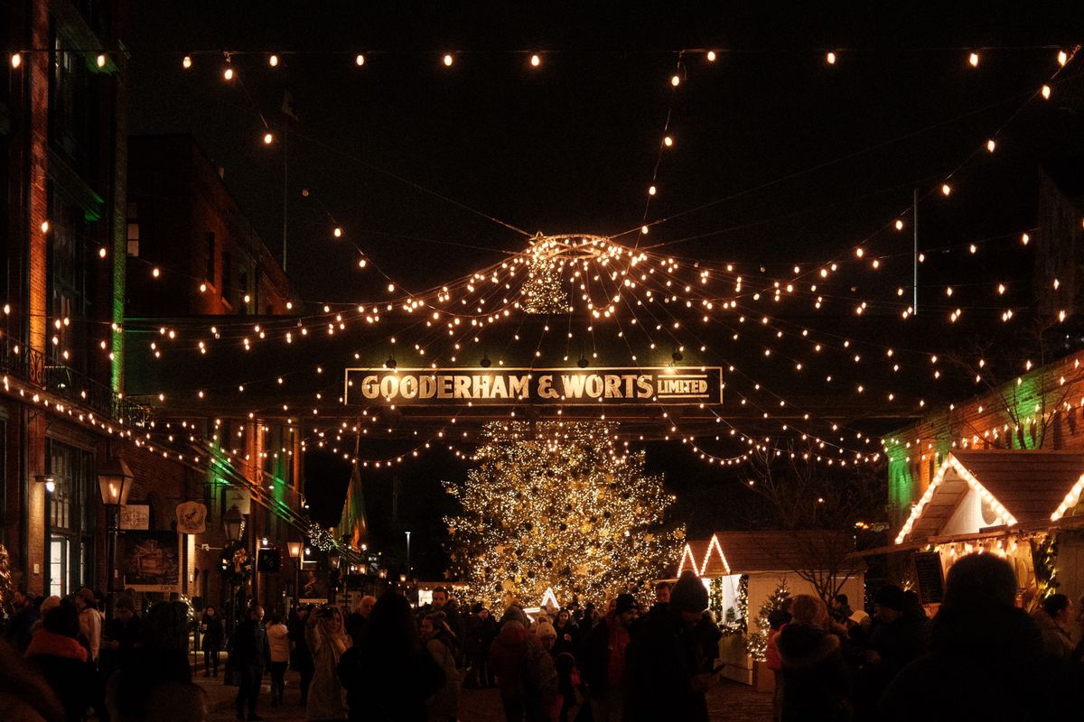 Bustling holiday market with Christmas lights at night