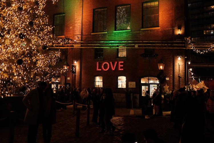 People Gathered Around A Big Christmas Tree