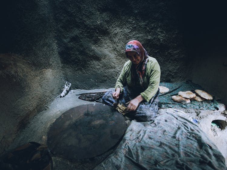 Senior Woman Making Pita Arabic Bread In Traditional Old Stone Oven