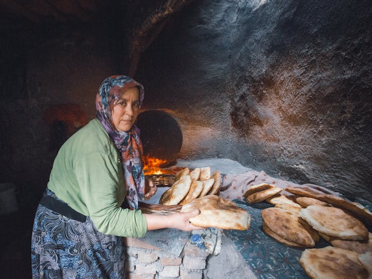 Senior Woman Making Arabic Bread On An Old Stone Oven