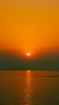 A breathtaking sunset over the sea with vibrant orange hues in Sambalpur, India.
