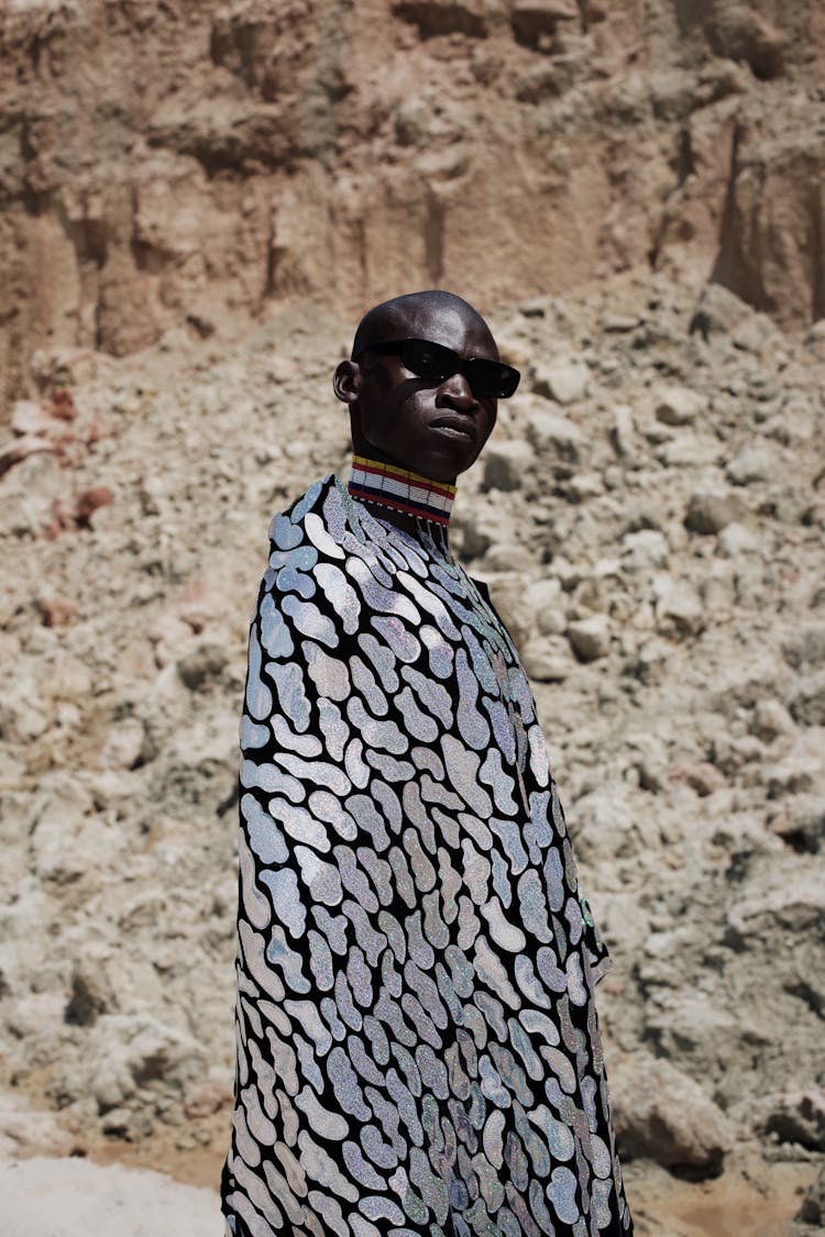 Man In Long Patterned Cape In Desert