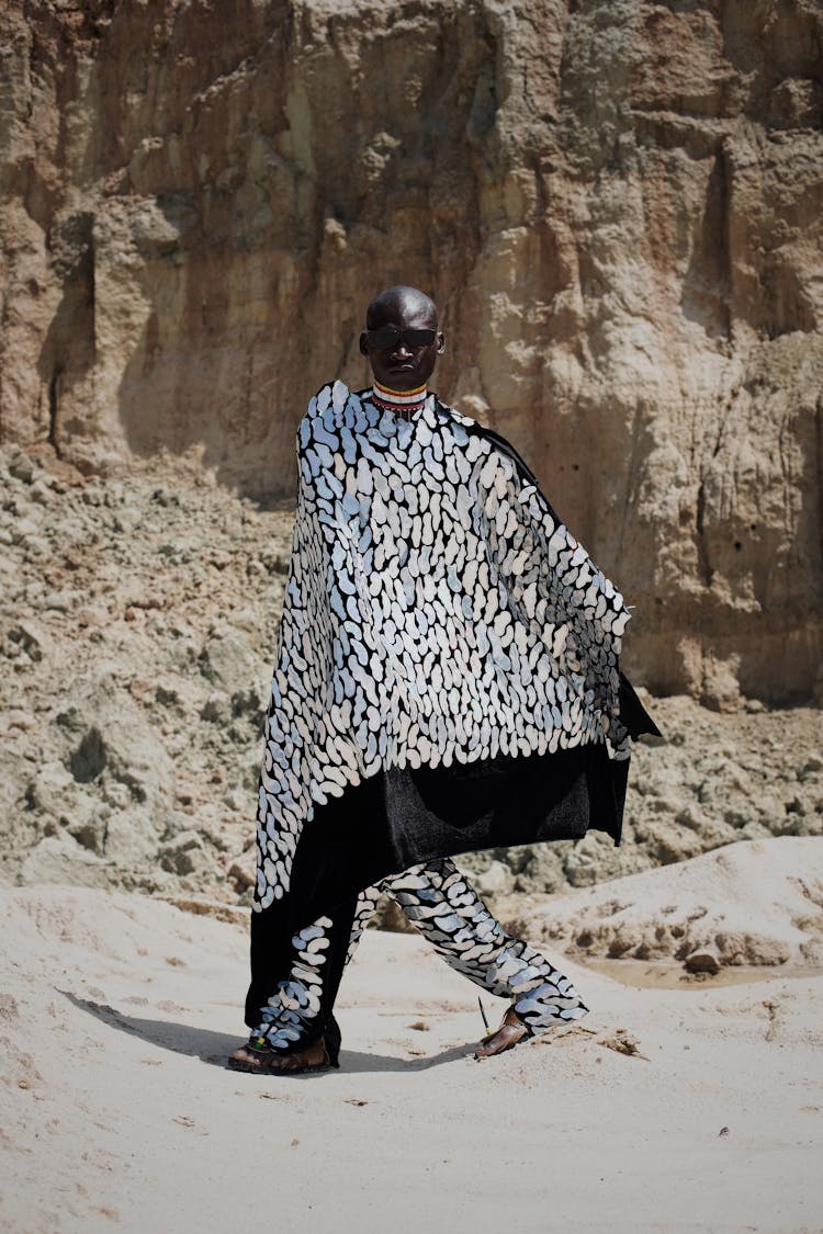 Person Dressed In Patterned Cape In Desert