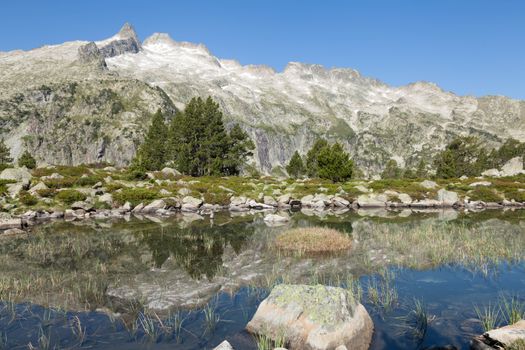 Stunning mountain landscape with reflections in a tranquil lake near Luz-Saint-Sauveur, France.