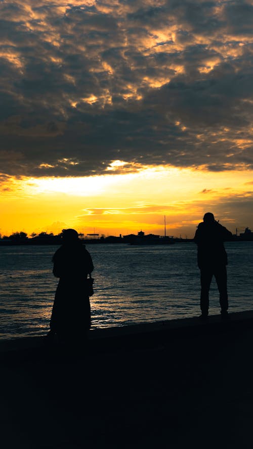 People Standing on the Beach During Sunset