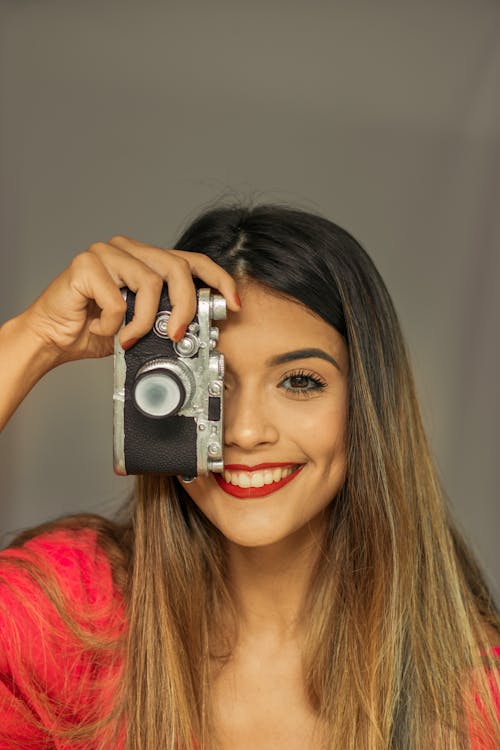 Smiling Woman Holding a Vintage Camera 