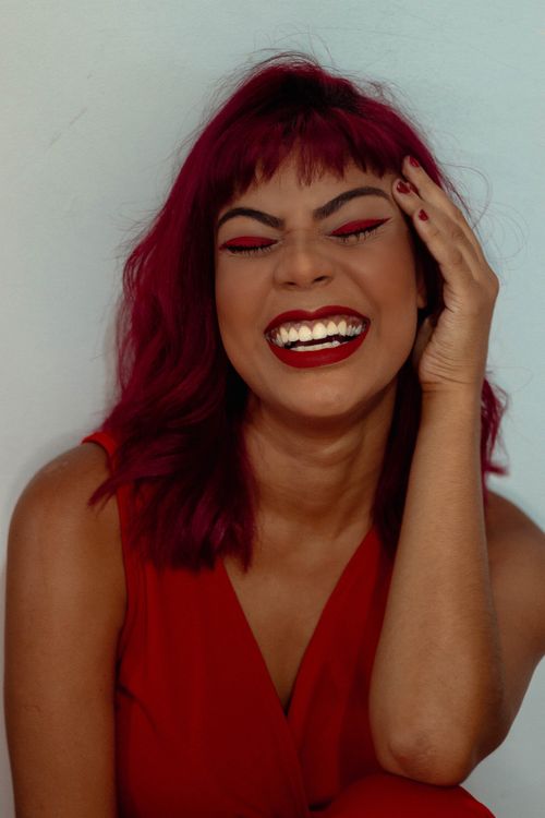 Free Vibrant portrait of a woman with red hair and makeup, exuding joy and confidence. Stock Photo
