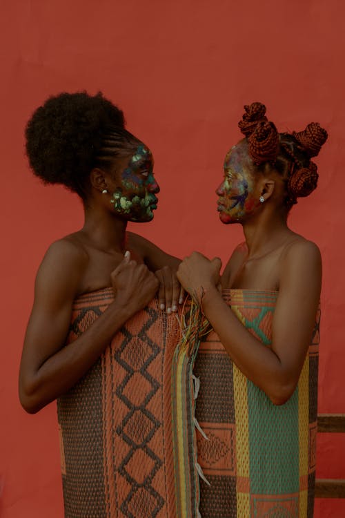 Women in Face Paint Wrapped in Traditional African Patterned Rug