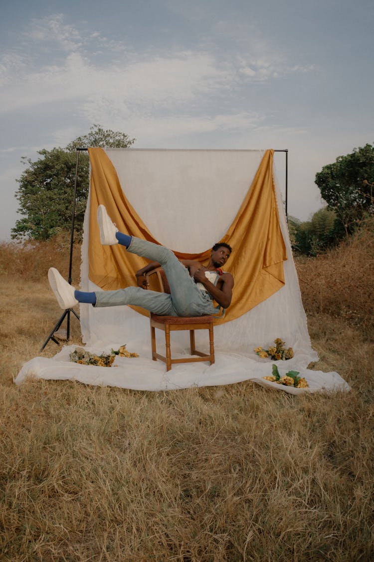 Man Lying On Chair On Scene Built In Field