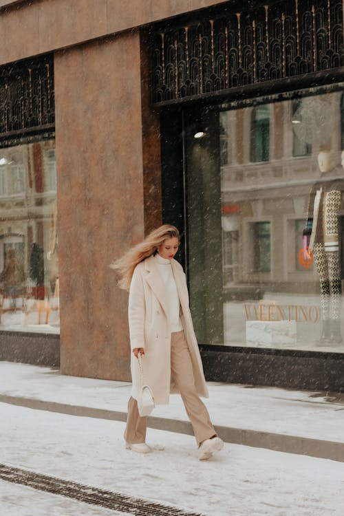 Woman in Coat Walking in Town in Snow