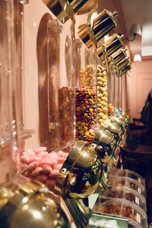 Free Vertical shot of colorful candies in dispensers at a cozy shop. Perfect for themes of abundance and choice. Stock Photo