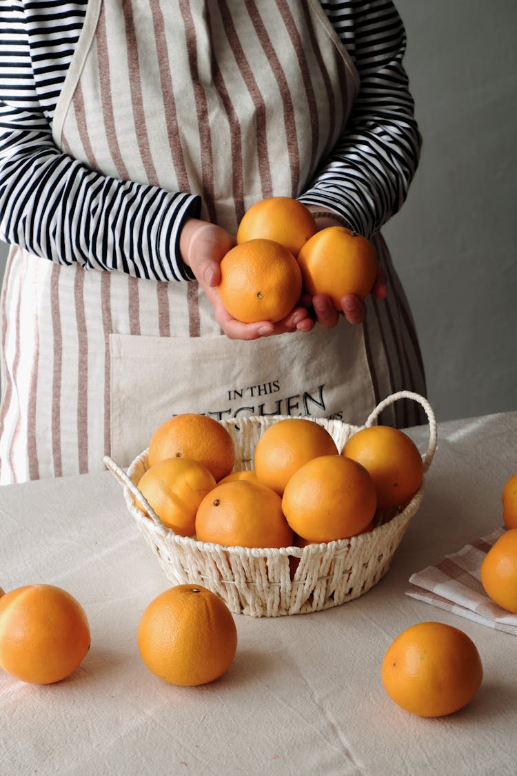 Woman With Oranges On Table