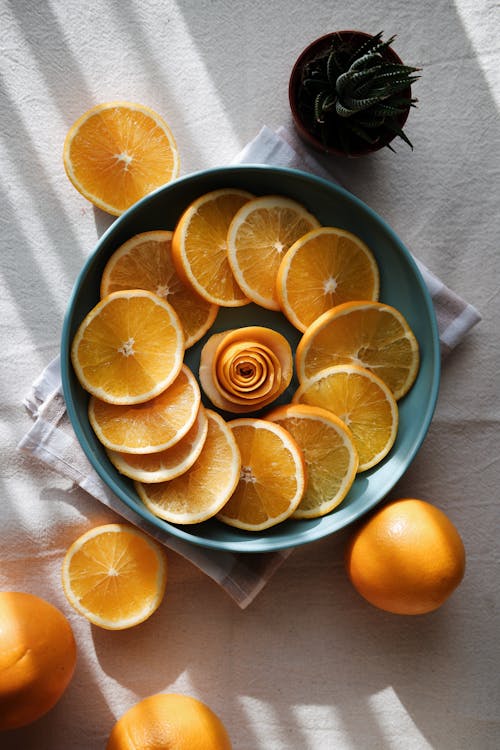 A Flatlay of Orange Slices in a Teal Blue Ceramic Plate