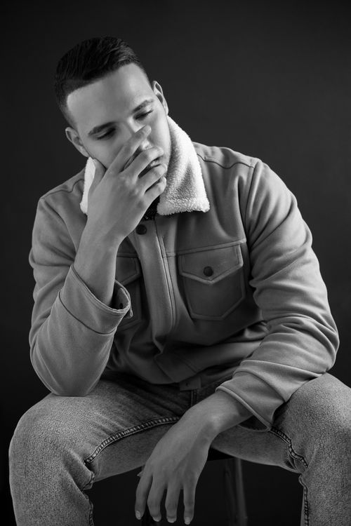 Free Black and white portrait of a man in thought, captured in a studio setting. Stock Photo