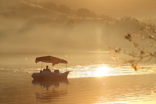 Silhouetted Boat on a Body of Water at Sunset