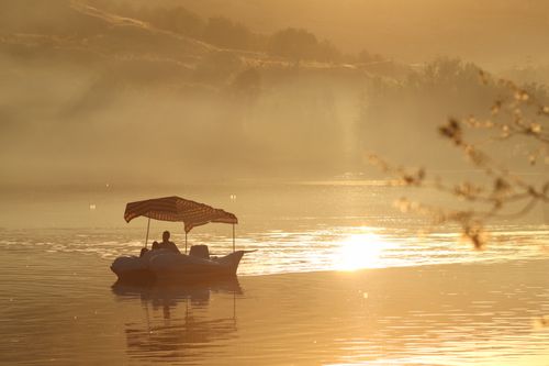 Free A peaceful boat ride during sunset in Malatya, Türkiye, showcasing a tranquil golden glow. Stock Photo