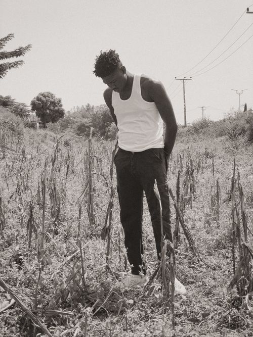 Free Black and white photo of a man standing in a barren field in Nigeria. Stock Photo