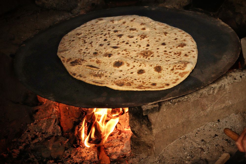 Flatbread baking directly against the hot wall of a wood-fired clay oven