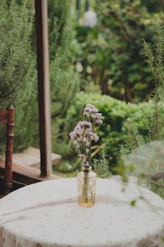 A peaceful garden patio in Đà Lạt with wildflowers in a vase on a rustic table.