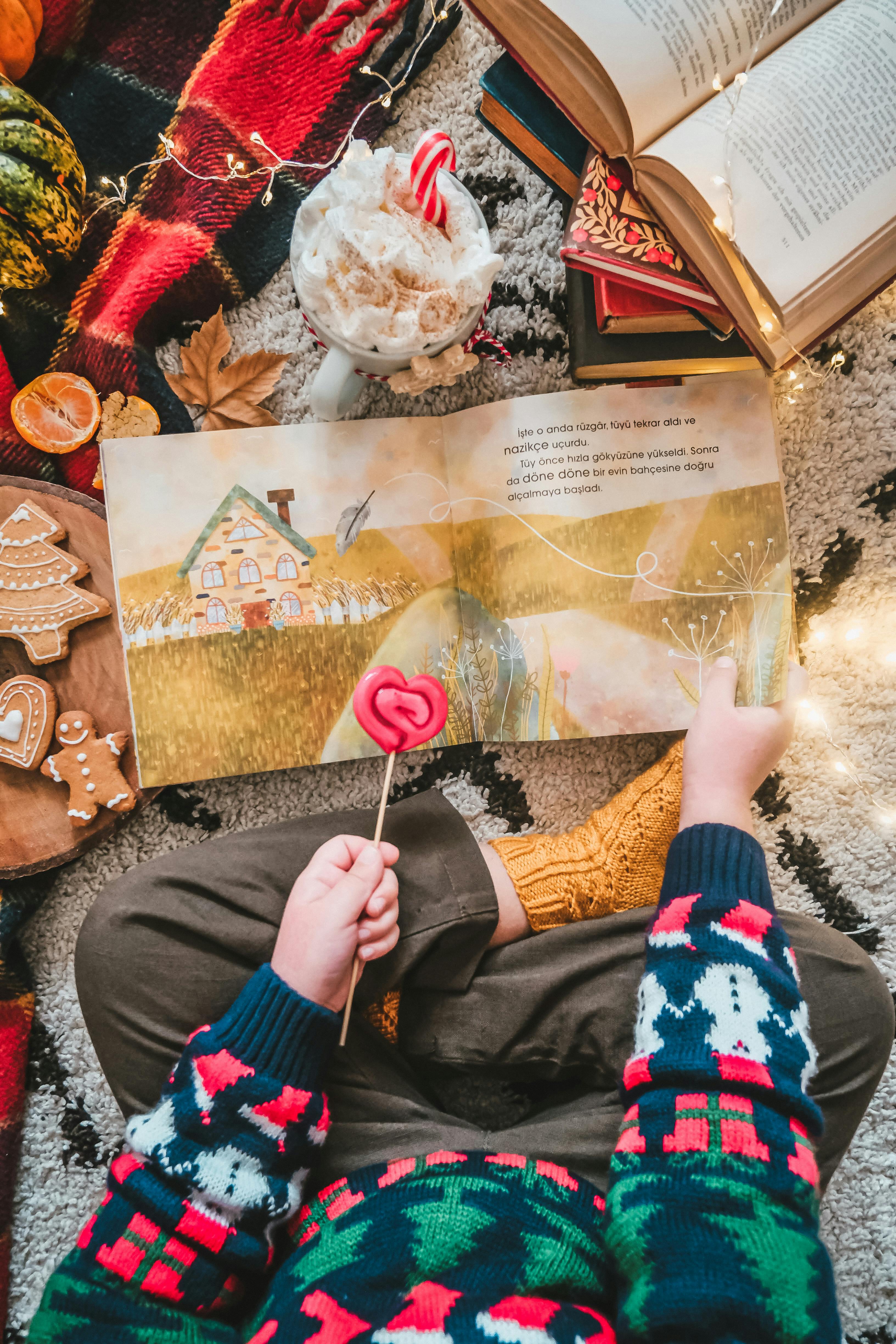 kid sitting on carpet with books and christmas cookies