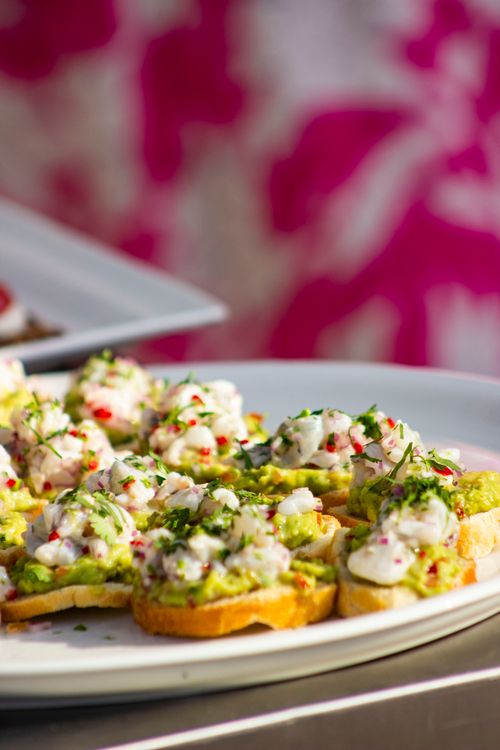 Free Appetizing crab and avocado bruschetta on a white plate with a vibrant background. Stock Photo